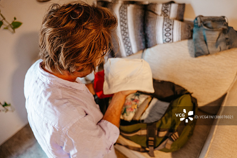 男旅行者打包行李将衣服放入行李袋图片素材