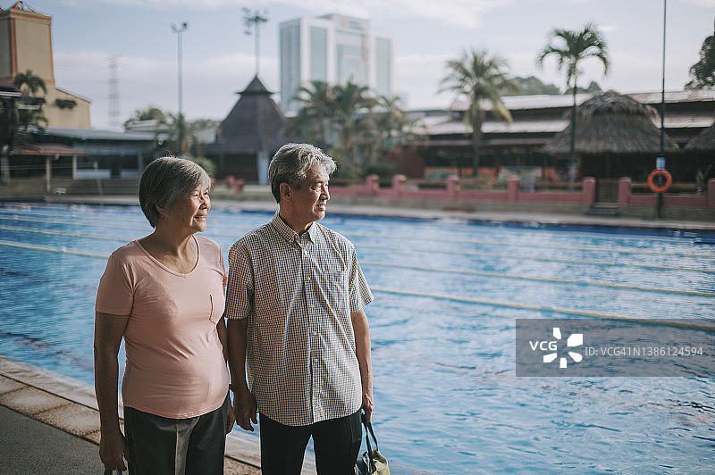 对早上的游泳课感到兴奋的亚洲老年夫妇到达游泳池图片素材