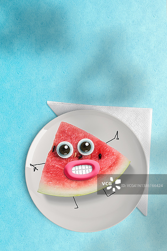 在蓝色夏季背景中，盘子上放着戴着假护目镜的快乐西瓜图片素材