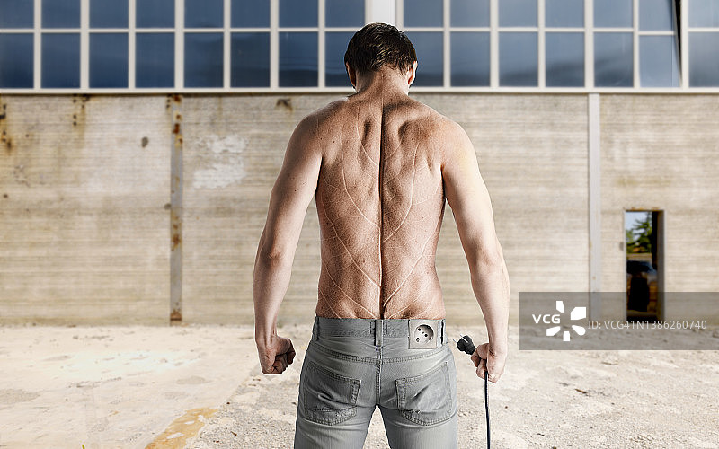 从后面看到的带电源插座的男人，皮肤像叶子，将太阳能转化为电能图片素材