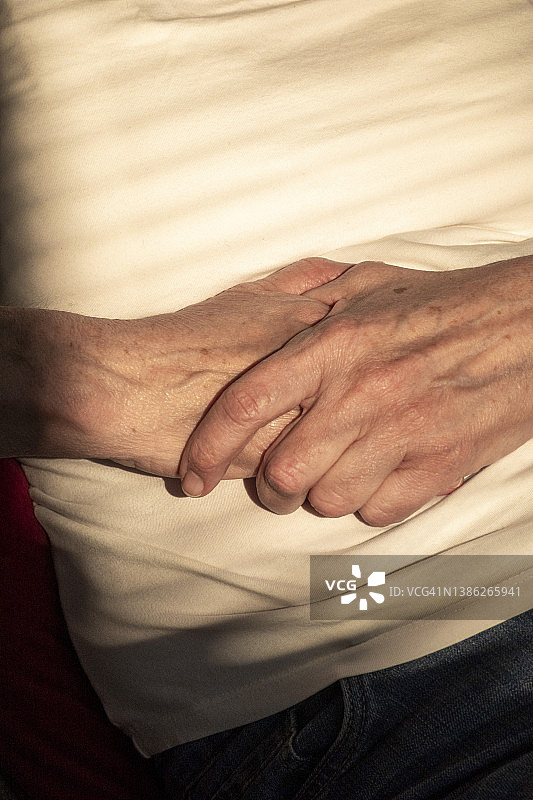 阳光照在老妇人的手上图片素材