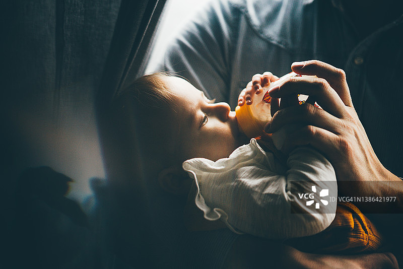 现代父亲用奶瓶喂宝宝图片素材