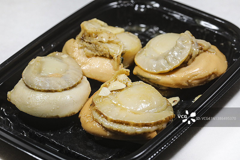 一次性塑料托盘中的烤扇贝图片素材