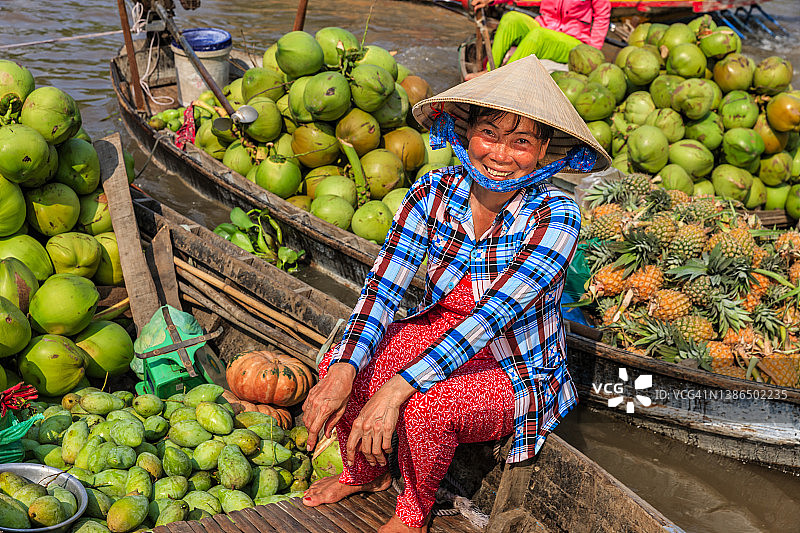 在越南湄公河三角洲水上市场卖水果的越南妇女图片素材