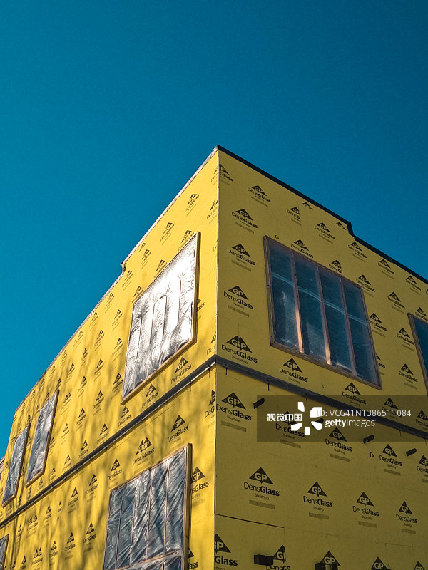 明黄色护套建筑材料与明亮蓝天形成对比图片素材