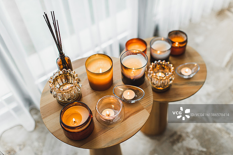 家中木桌上不同烛光中的香薰蜡烛图片素材