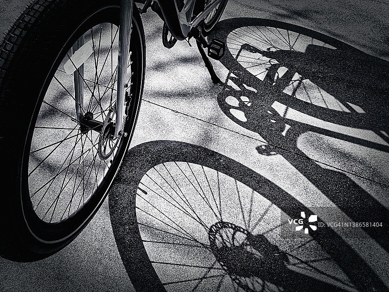 黑白电动自行车：长长的影子，清洁能源运动，电池驱动图片素材