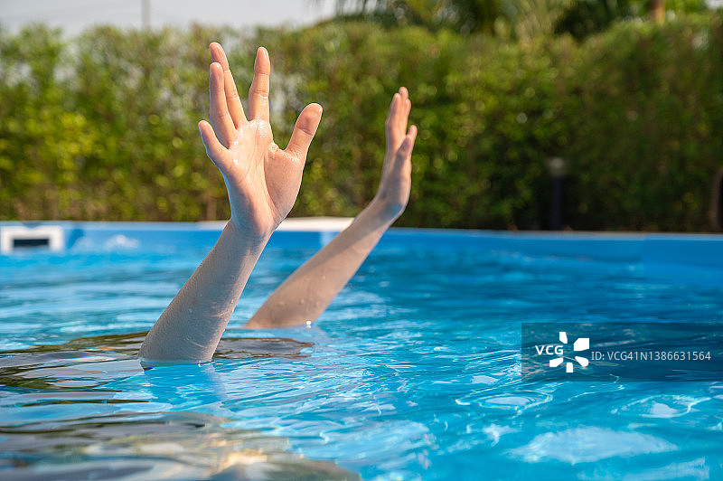 女子在游泳池中溺水，展示双手图片素材