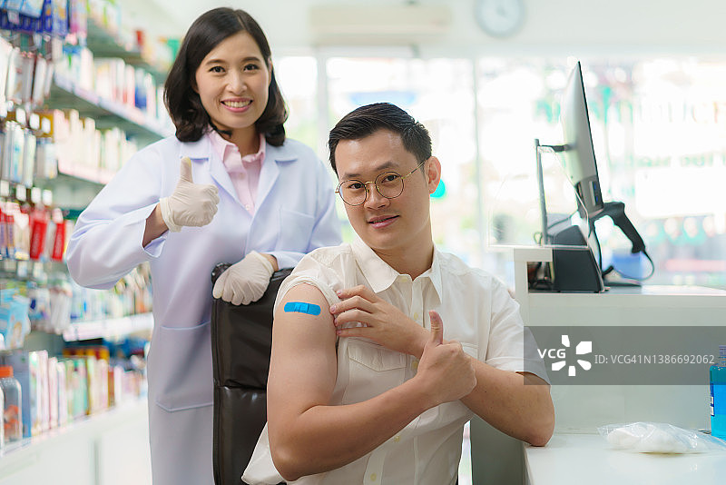 亚洲男人在药店接受疟疾、破伤风、伤寒、肝炎疫苗，准备旅行图片素材