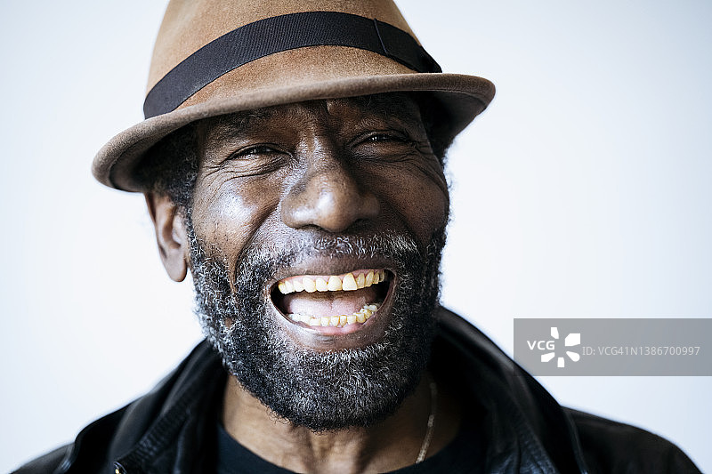戴着porkpie帽的时尚老年男士开怀大笑图片素材