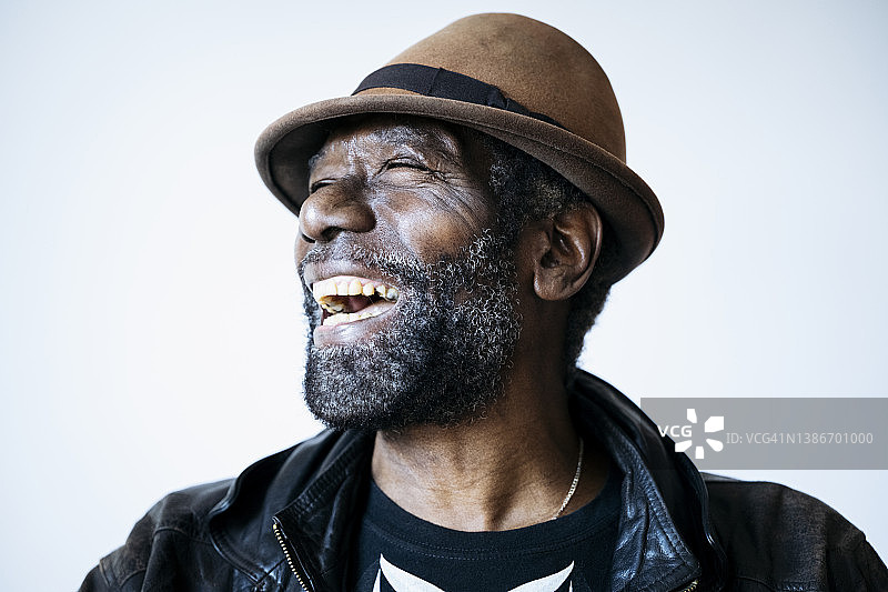非裔加勒比地区老年黑人男子笑着看向远方的抓拍肖像图片素材
