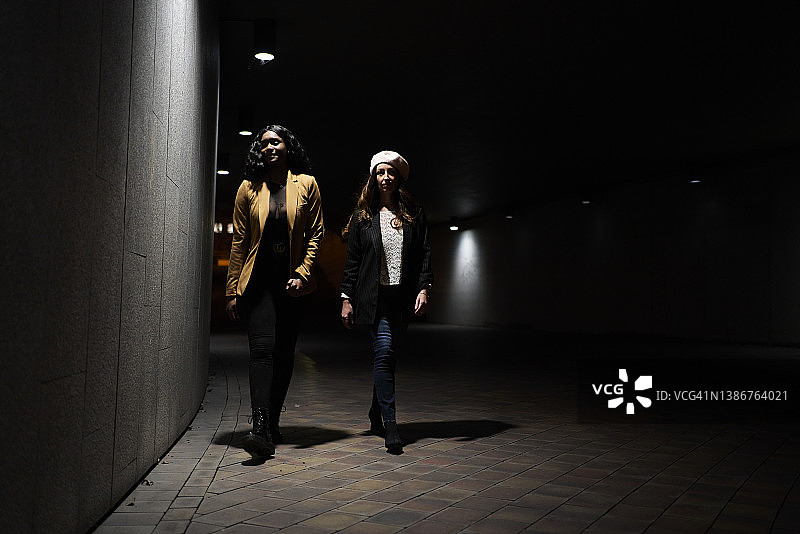 夜晚地铁站，两个女人赶往城市酒吧与朋友相聚图片素材