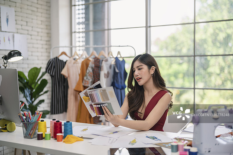 自信的时装设计师正在她的展示厅工作图片素材