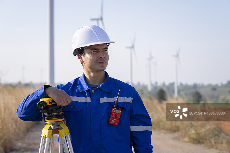 工程师在风力发电场使用测量设备的肖像图片素材