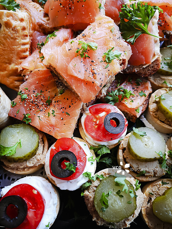 美味食品拼盘：烟熏三文鱼和奶油奶酪小吃，俯视微距图片素材