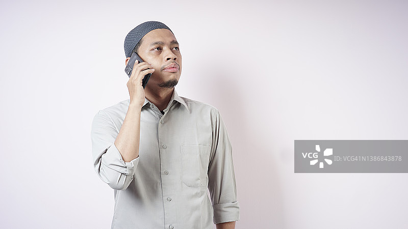 亚洲穆斯林男子用智能手机打电话图片素材