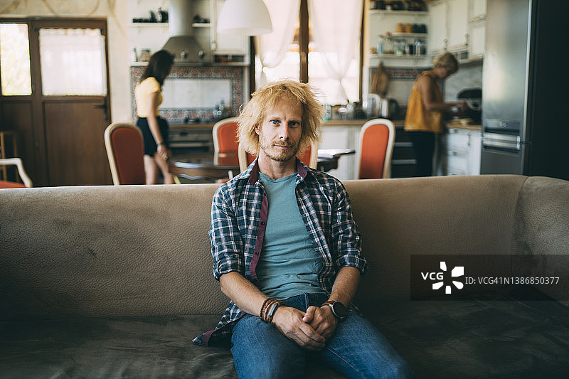 不开心的男人坐在沙发上看着镜头图片素材