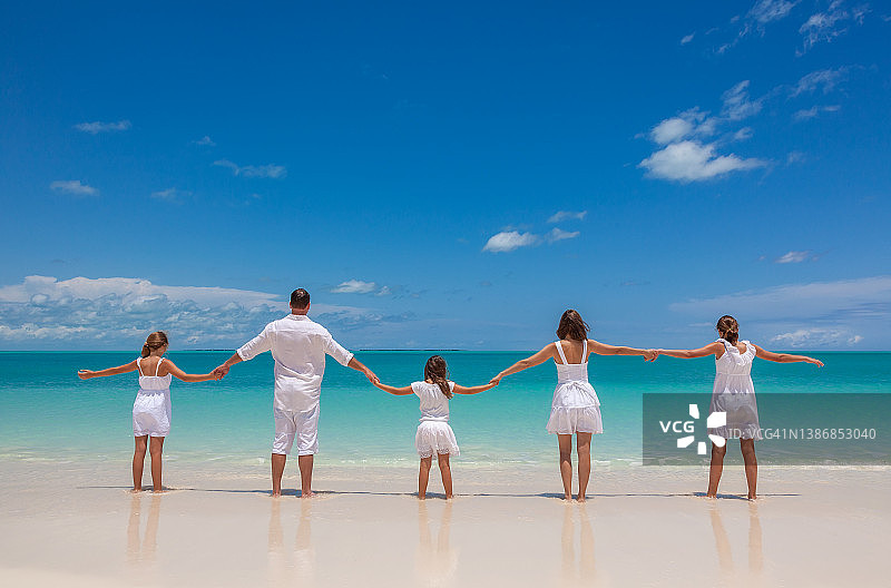 年轻的白人父母和孩子在海滩上玩耍图片素材