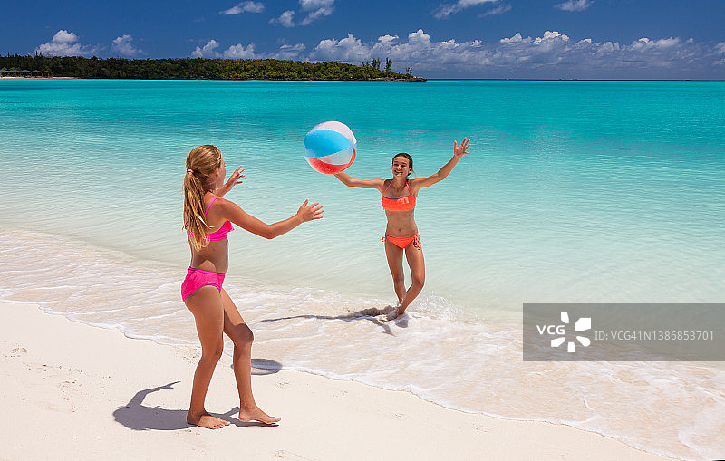 女孩们在海滩悠闲地玩球图片素材