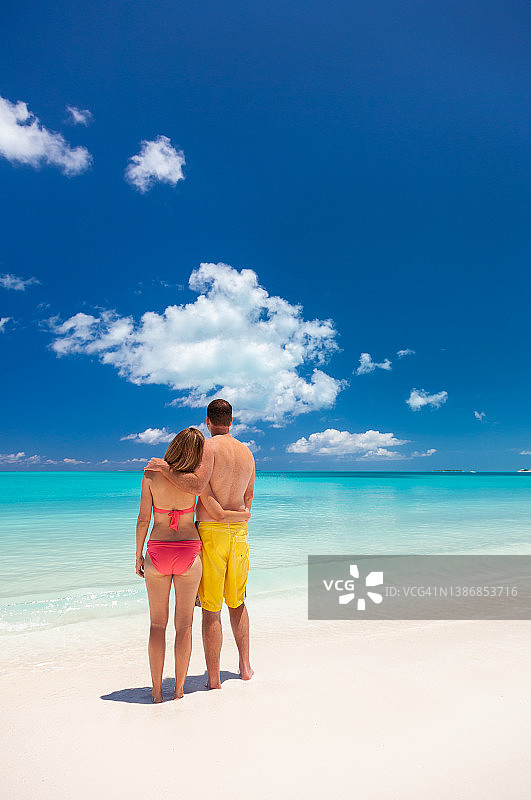 快乐的白人夫妇在豪华海滩上赤脚漫步图片素材