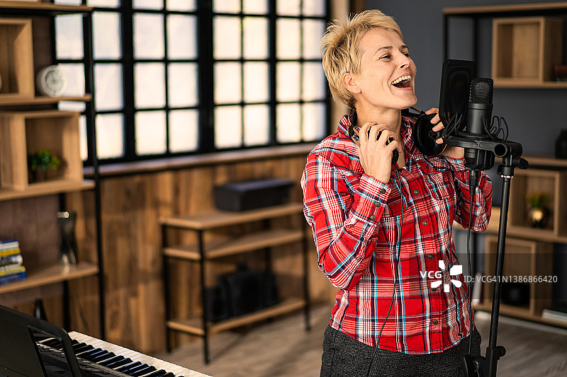 在录音室唱歌的年轻女人图片素材