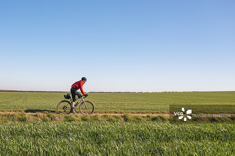 骑行者在穿过农田的砾石路上骑行图片素材