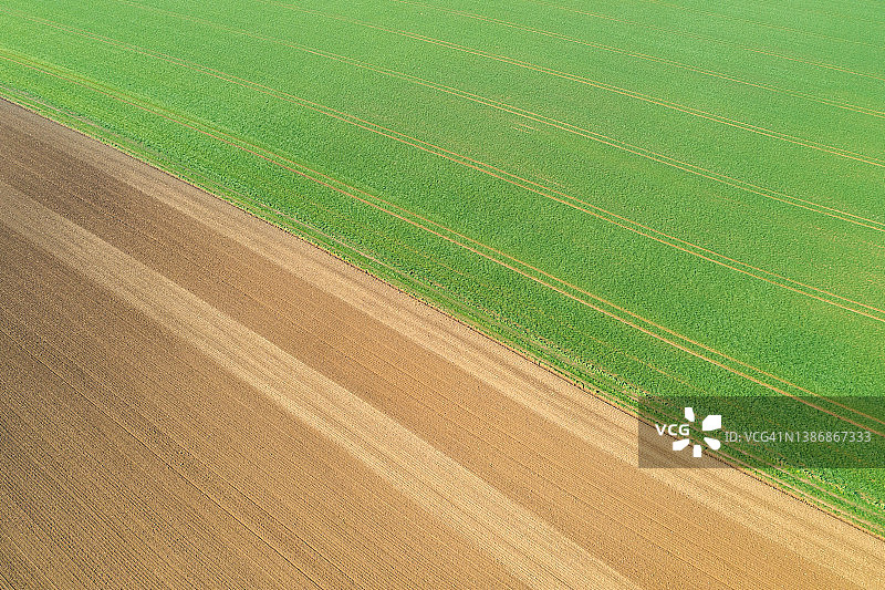 农业用地的无人机视角，一侧是耕地，另一侧是土壤图片素材