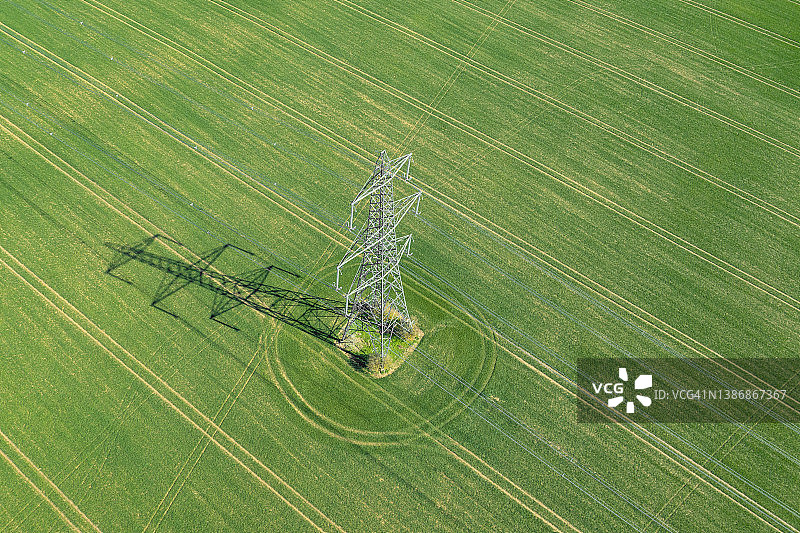 绿色农田中电力塔的无人机视角图片素材