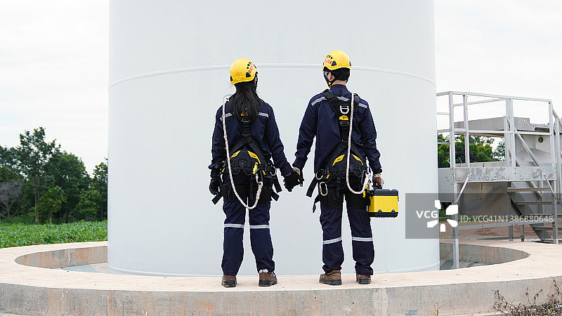 两名电气工程师在风力涡轮机场工作图片素材