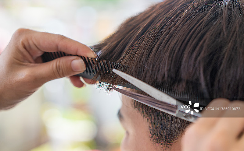 女人用剪刀剪下一绺头发图片素材