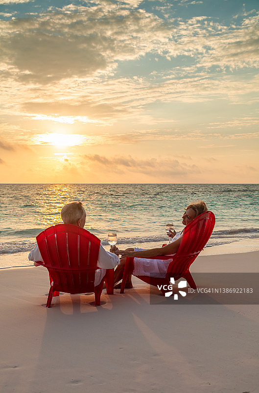 恩爱的年长夫妇在海滩上放松品酒图片素材