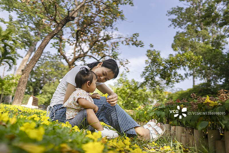 亚洲母女在公园户外摘下口罩，享受休闲时光图片素材