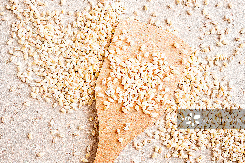 木勺和桌子上的生大麦特写，顶视图图片素材