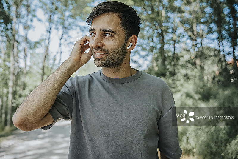 男人通过蓝牙耳机听音乐图片素材