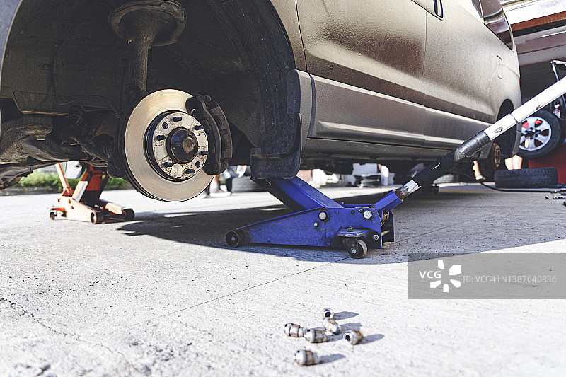 在汽车修理店拆卸轮胎的汽车图片素材