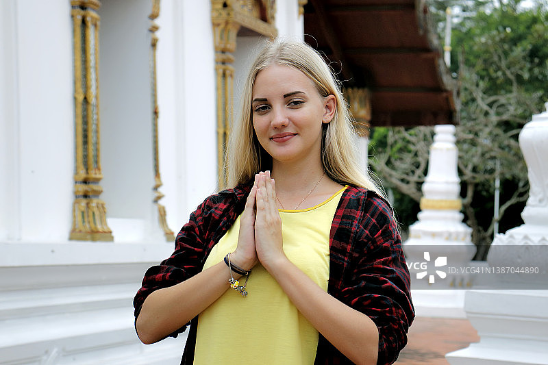 旅行女人双手合十于胸前，表示尊重图片素材