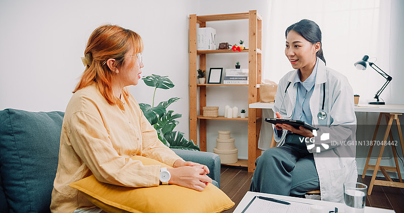 亚洲女心理医生与患者交流心理健康问题，帮助其恢复健康图片素材