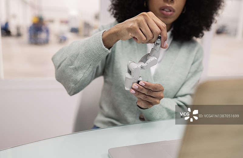 女商人通过笔记本电脑视频通话讲解机械手臂模型图片素材