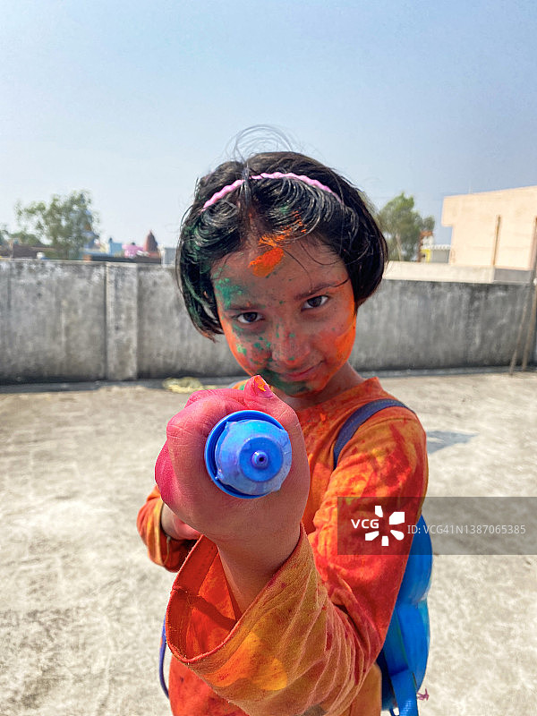 印度教女孩在洒红节上玩耍，身上涂满颜料图片素材