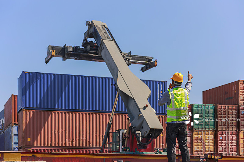 年轻的工程师在集装箱货物仓库工作，进行质量控制业务物流、进出口运输或火车货运。图片素材