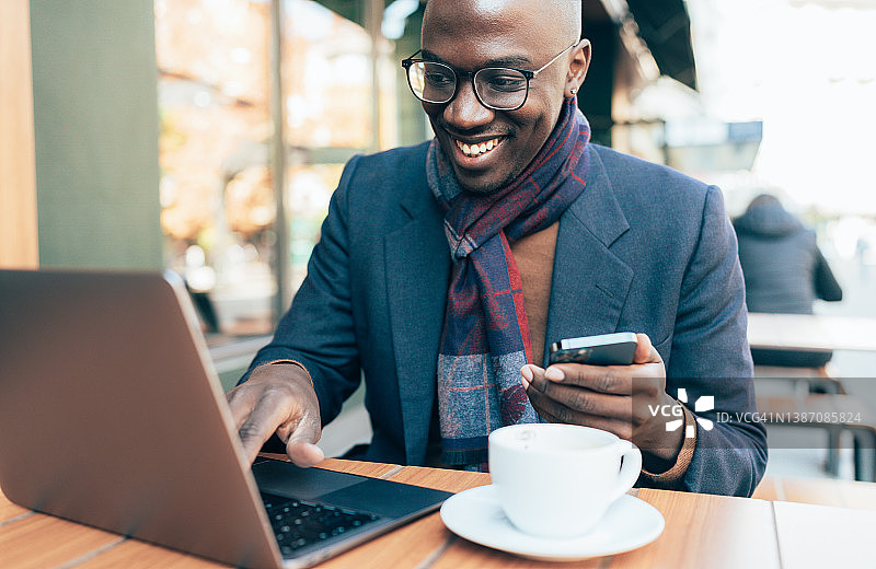 年轻男人坐在咖啡店里使用笔记本电脑图片素材