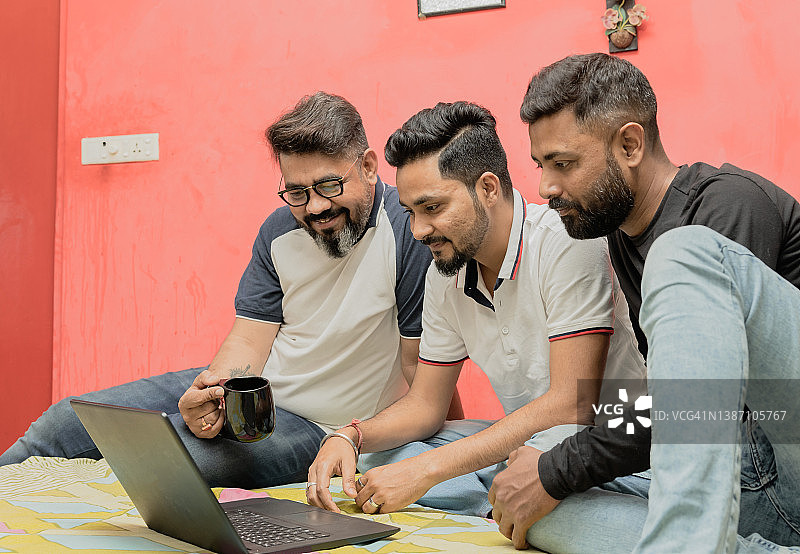 几位印度男人在古瓦哈提家中用笔记本电脑看电影图片素材