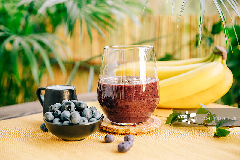 玻璃杯中的新鲜蓝莓香蕉冰沙。图片素材