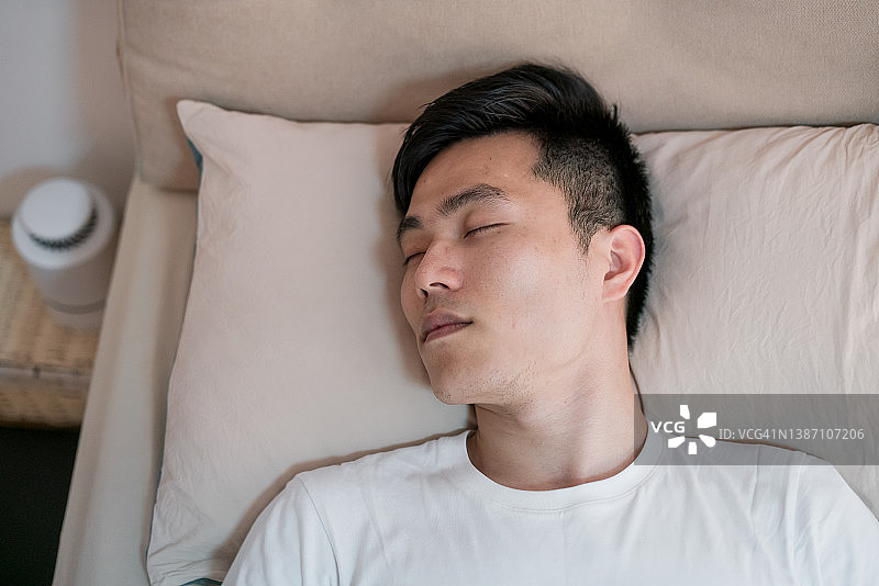 在房间里睡觉的亚洲男人图片素材