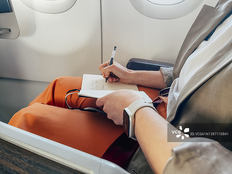 在飞机上制定计划的女商人特写图片素材
