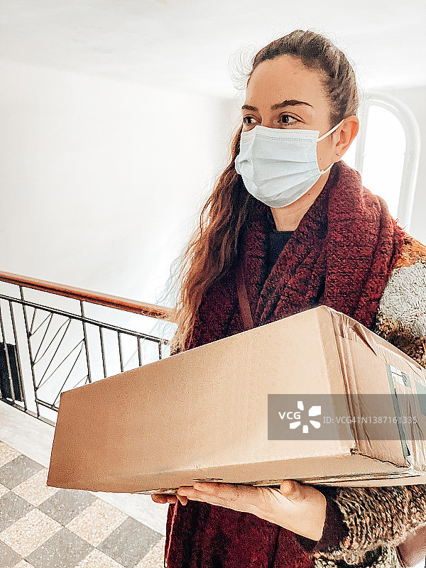 戴着口罩拿着盒子的女人图片素材