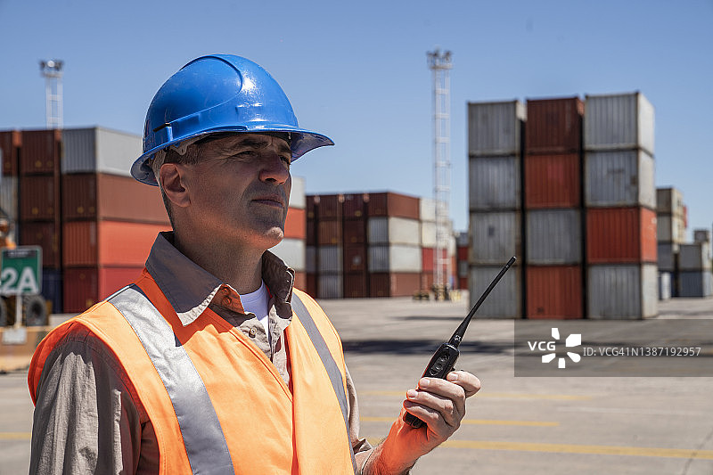 在货运码头拿着对讲机的男性工头图片素材
