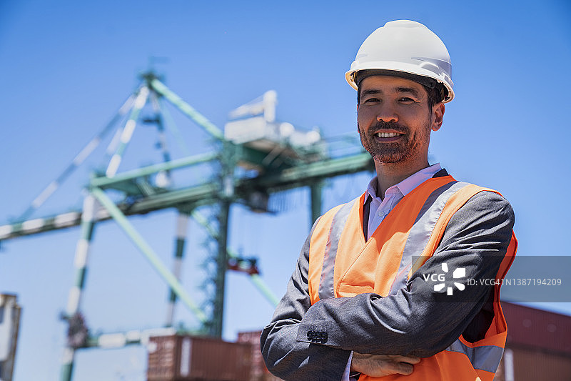 亚裔美国男性国际贸易代理人，双臂交叉看着镜头图片素材