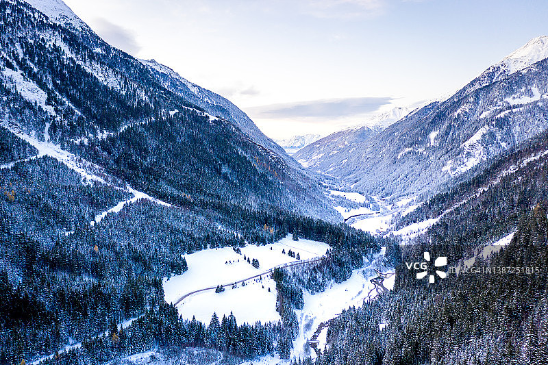 雪覆盖的森林道路冬季航拍景观图片素材