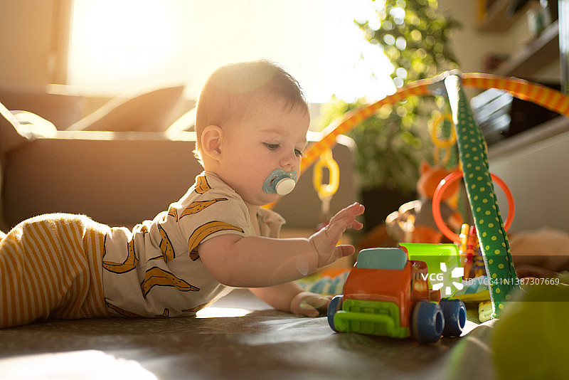 好奇的白人男婴玩玩具卡车图片素材